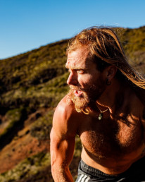 Ultraläufer Timothy Olson in weiter Landschaft, oben ohne und mit wehenden langen Haaren