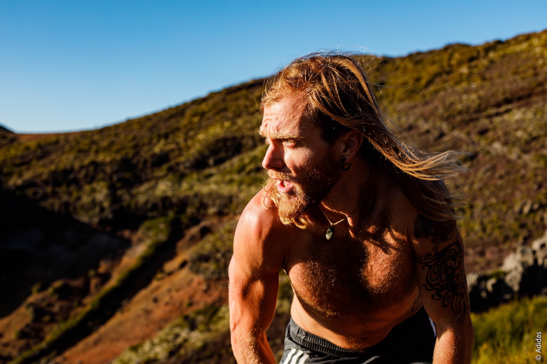Ultraläufer Timothy Olson in weiter Landschaft, oben ohne und mit wehenden langen Haaren