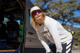 Ultraläufer Timothy Olson in gebückter Haltung vor einem Van mit Basecap