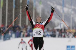 Felix Gottwald bei seinem Olympiasieg in der NOrdischen Kombination in Turin, im Ziel die Arme hochreckend