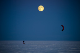 Abenteurer und Polarforscher Sebastian Copeland in der Arktis auf Eis mit einem Kite, der seinen Schlitten zieht