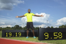 Usain Bolt vor Zeittafeln mit seinen Weltrekorden über 100 Meter und 200 Meter