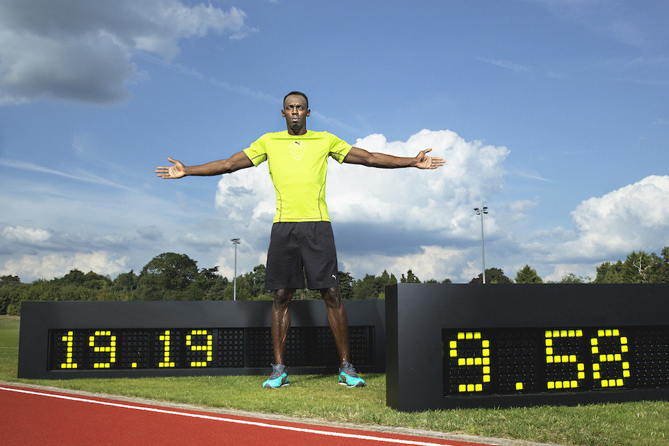Usain Bolt vor Zeittafeln mit seinen Weltrekorden &uuml;ber 100 Meter und 200 Meter