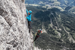 Bergsteiger Simon Messner am Sass dia Crusc / Heiligkreuzkofel in der Wand mit Panorama ins Tal