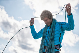 Bergsteiger Simon Messner vor blauem Himmel mit Kletterseil am Heiligkreuzkofel
