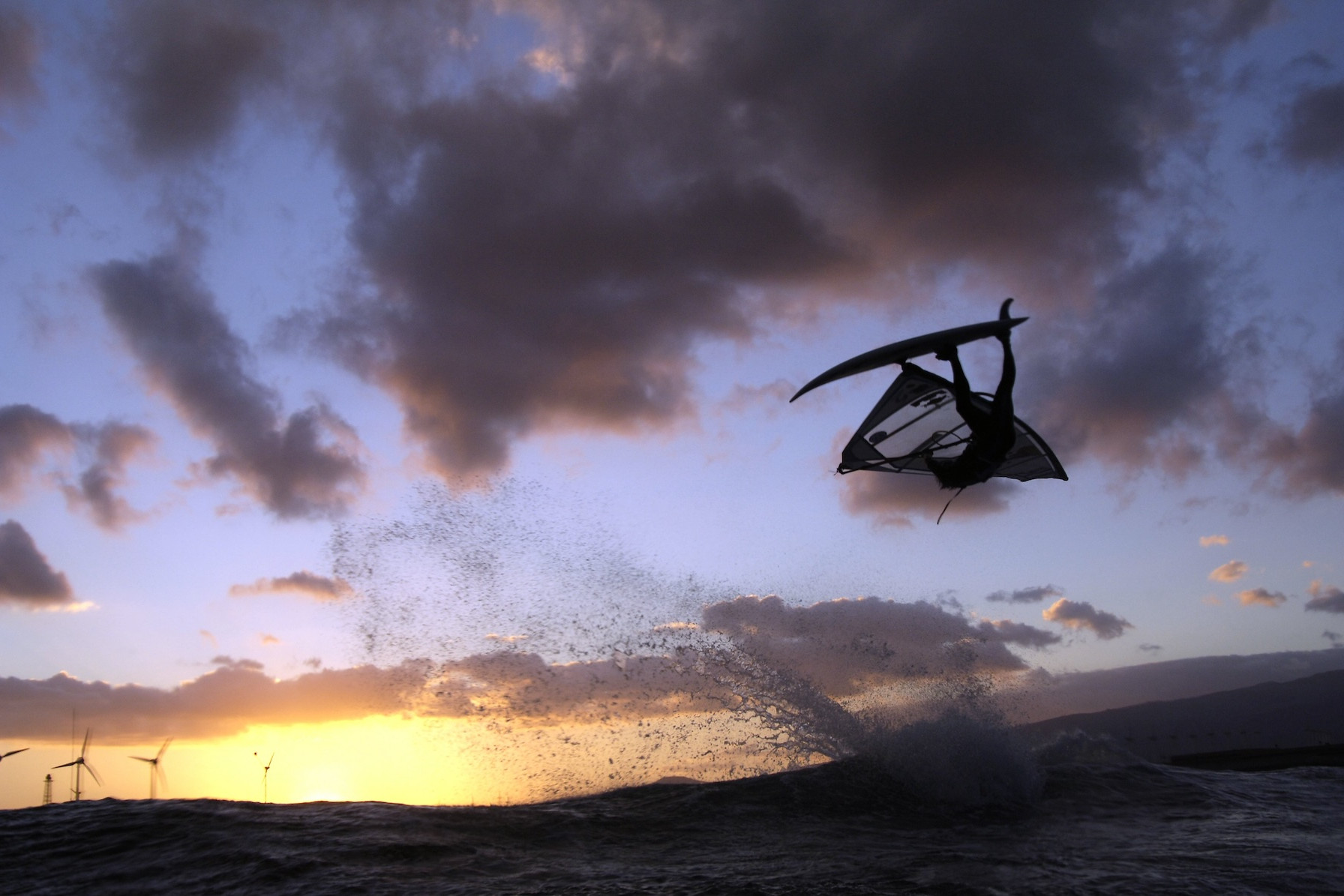 Windsurf-Weltmeister Bjørn Dunkerbeck beim Windsurfen mit einem Table Top Aerial in dramatischer Stimmung